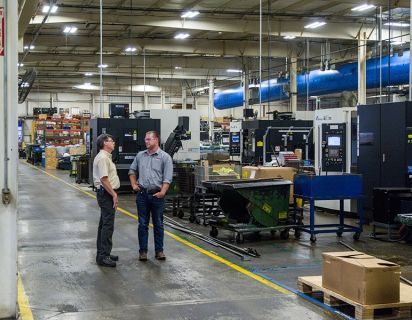 Two men talking on manufacturing plant floor