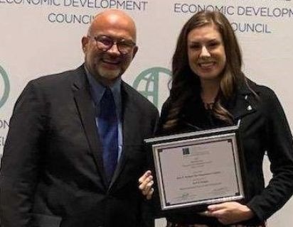 Hello West Michigan Executive Director Rachel Gray at IEDC's Excellence in Economic Development Awards holding the award that Hello West Michigan won.